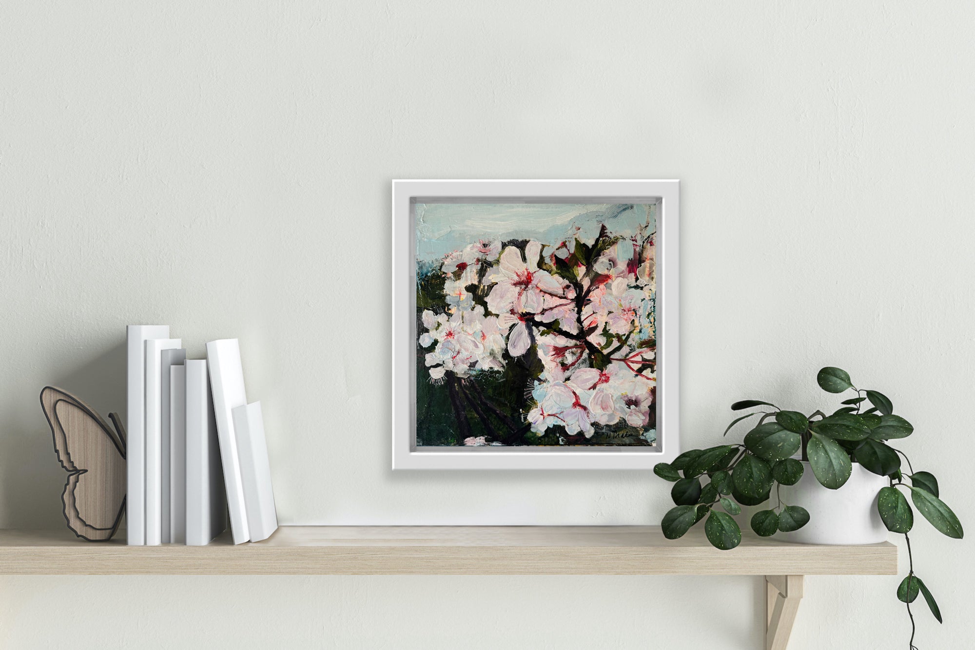 A painting of wild plum blossoms hangs above a shelf.